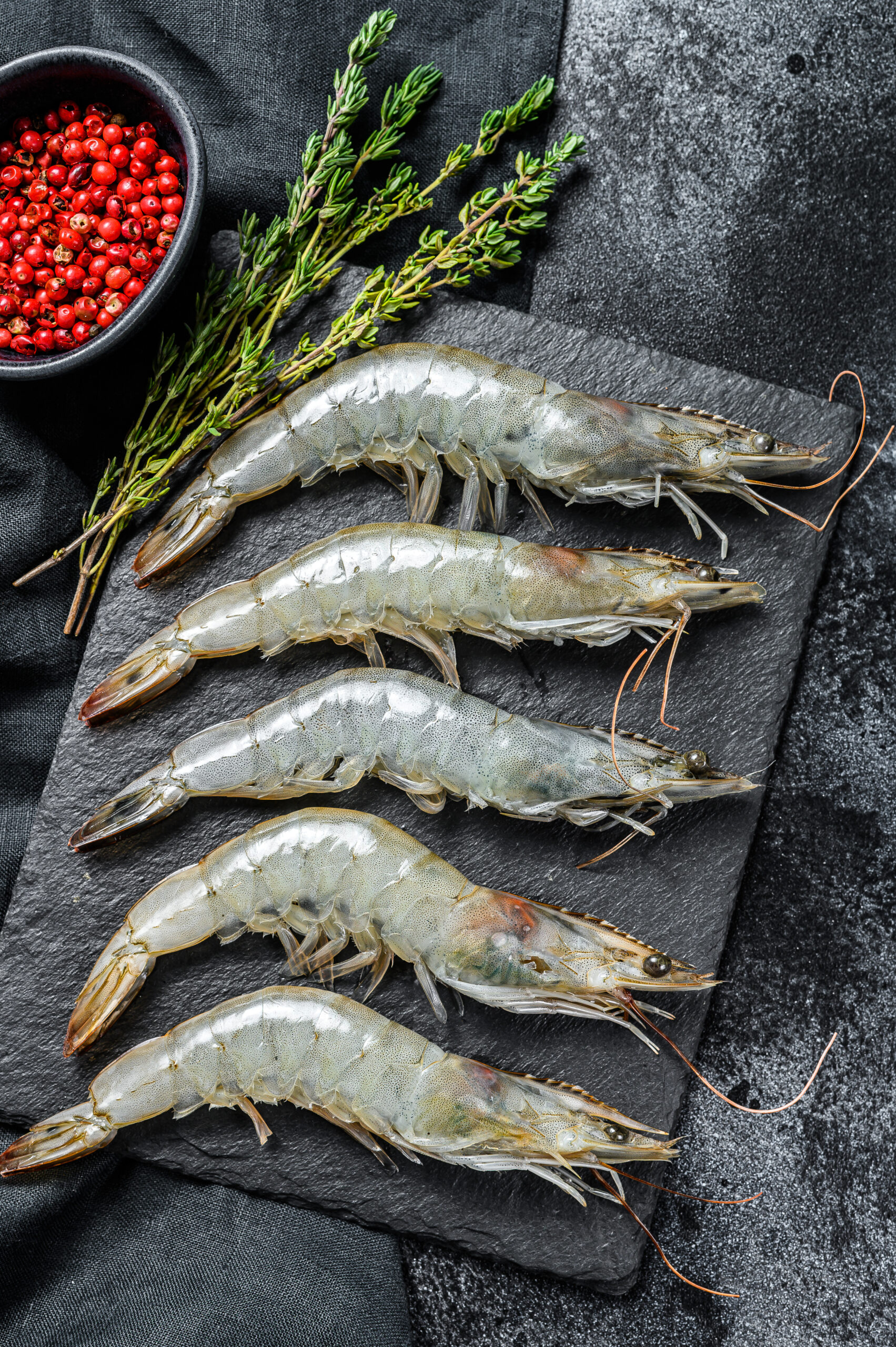 Whole fresh raw giant shrimps, prawns. Black background. Top view.